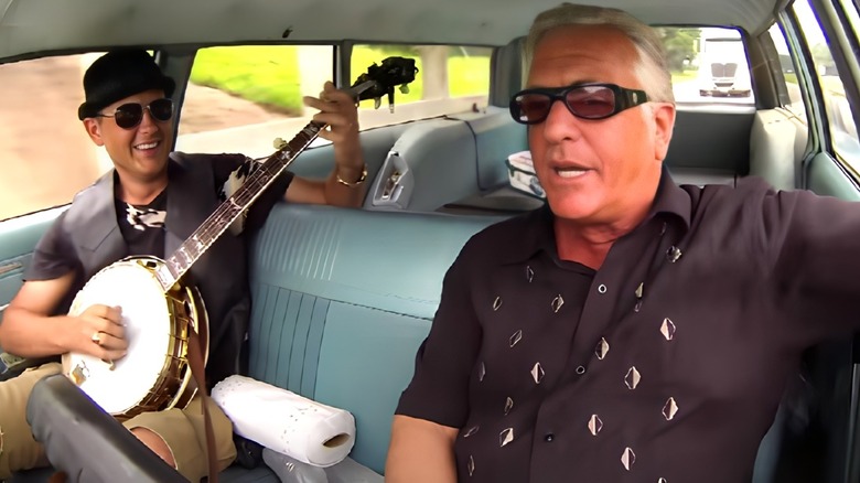 Barry Weiss driving while a man plays the banjo