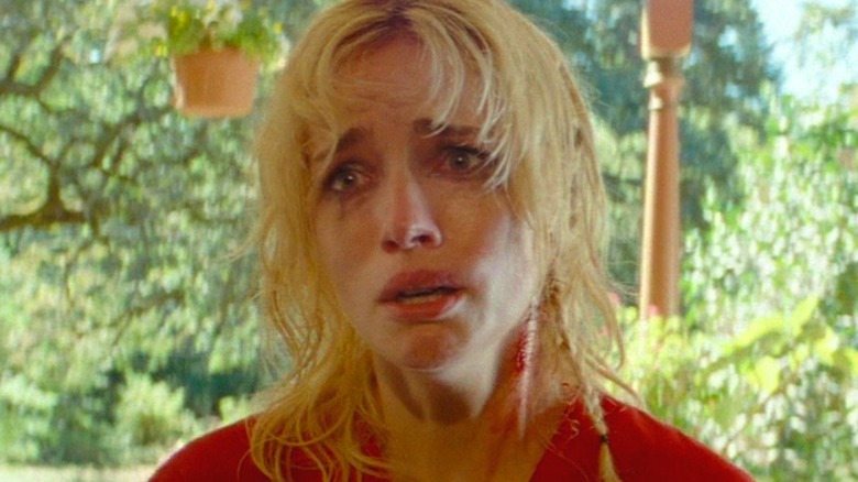 The Lady looking terrified on front porch in "Strange Darling" (2024)