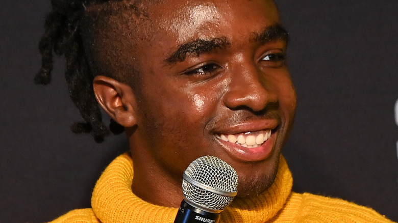 Caleb McLaughlin with mic, smiling