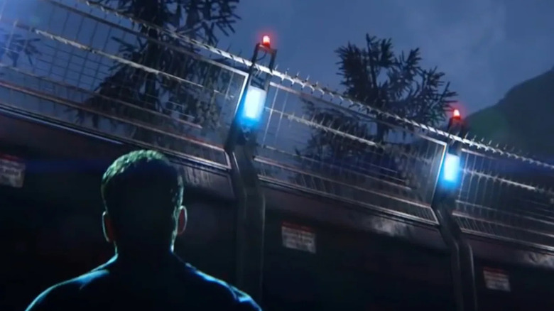 Ethan Burke looks up at a futuristic steel gate with bright lights and barbed wire keeping him out in "Wayward Pines"