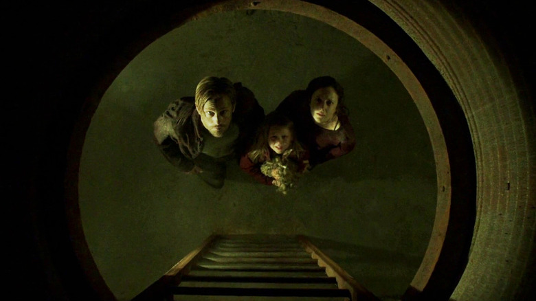 Alexander Skarsgard, Emily Alyn Lind, and Andrea Riseborough looking up in Hidden