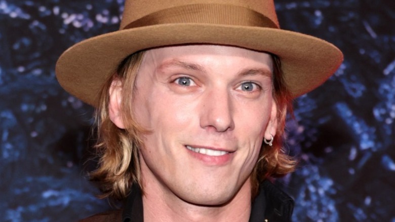 Jamie Campbell Bower wearing a hat