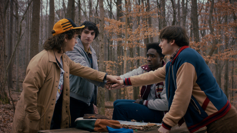 Dustin Mike Lucas and Will putting their hands in together on Stranger Things 5