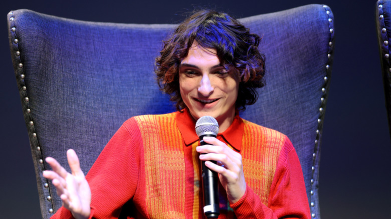 Finn Wolfhard talking into a microphone