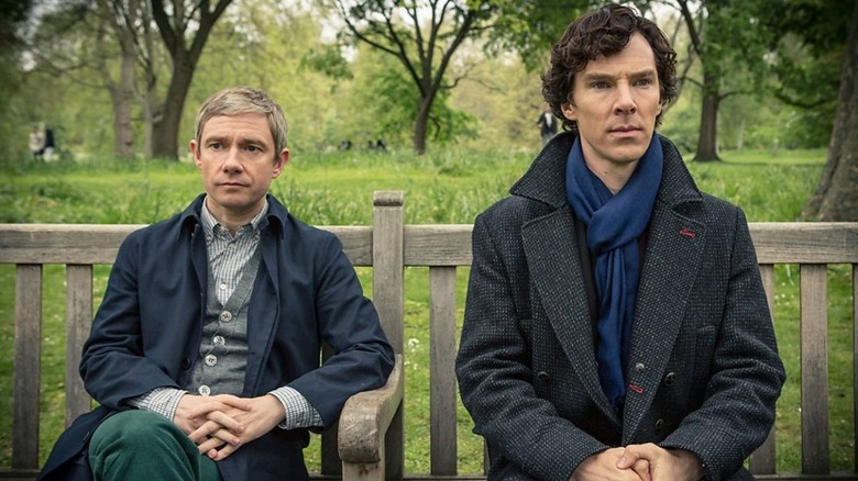John Watson and Sherlock Holmes sitting on a park bench in Sherlock