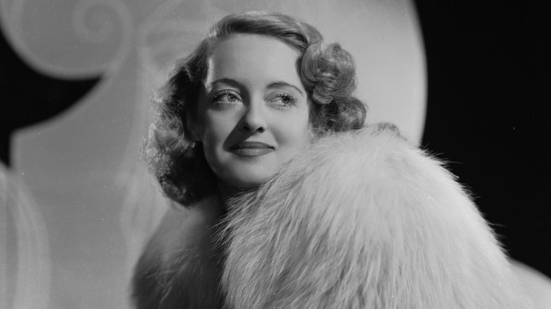 Bette Davis posing in fur coat