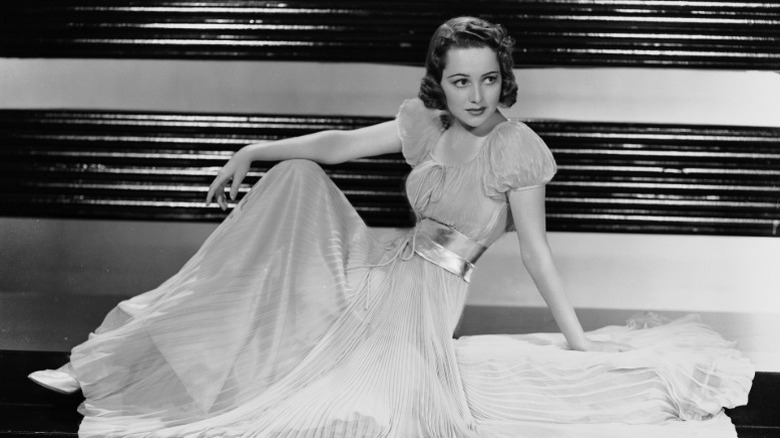 Olivia de Havilland sitting on a staircase-shaped stage