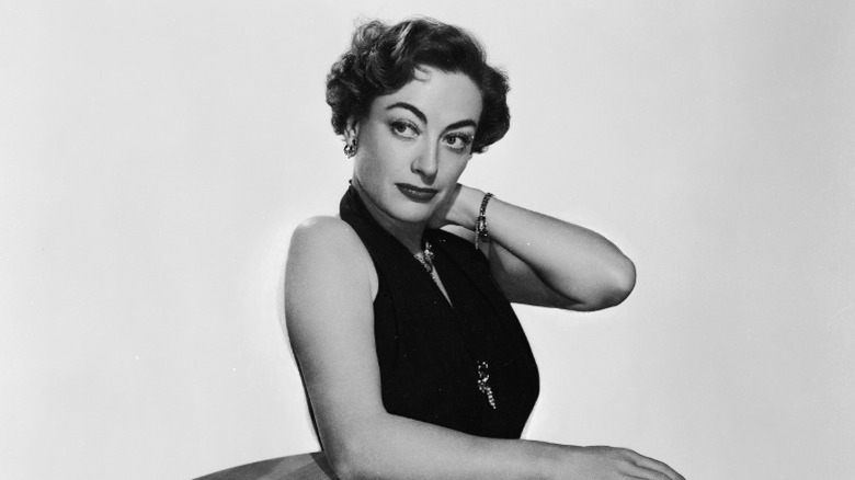 Joan Crawford resting her arm on a table