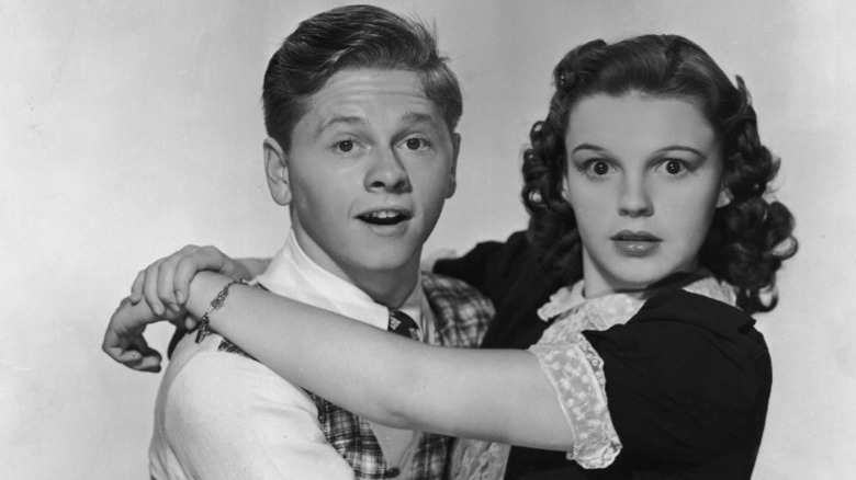 Mickey Rooney and Judy Garland embracing and looking at the camera