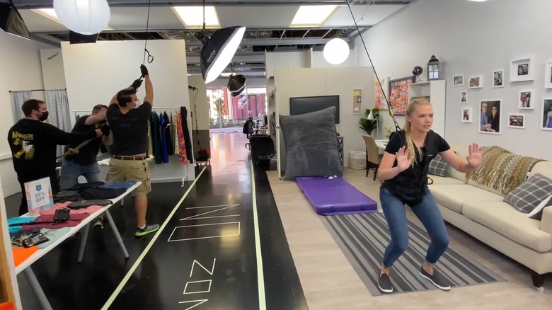 A stunt woman preparing to be pulled backward