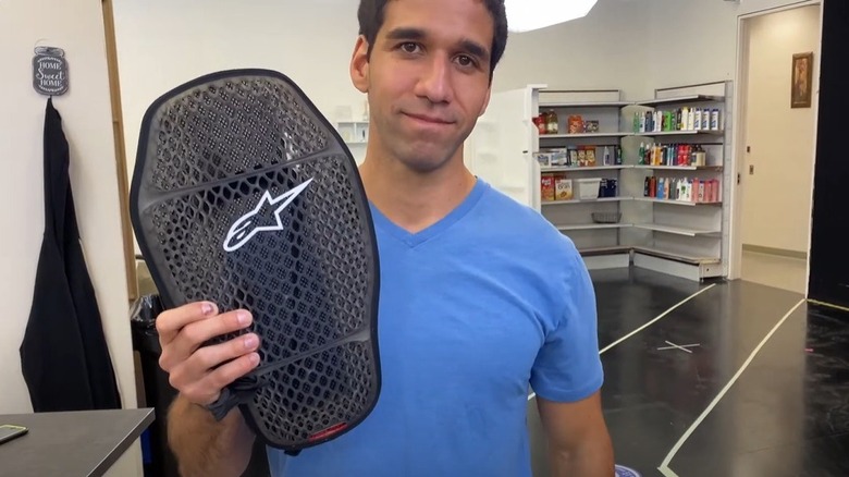 A stuntman holding up a back brace
