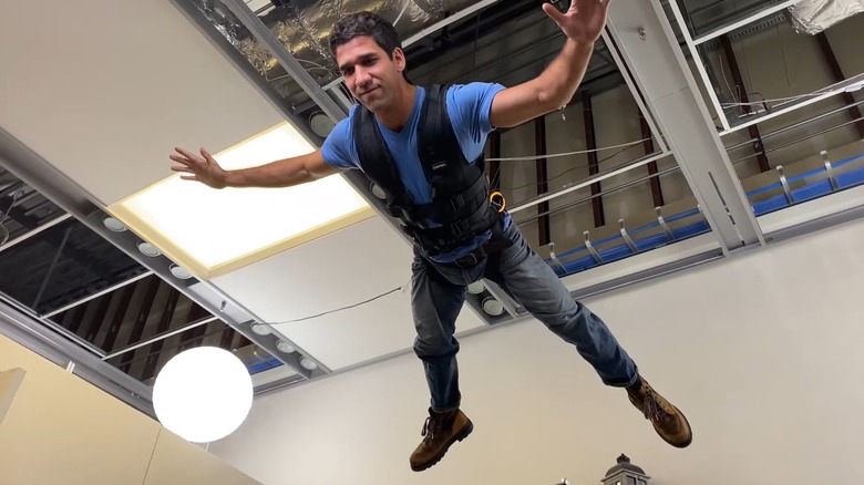 A stunt man suspended by wire rigging
