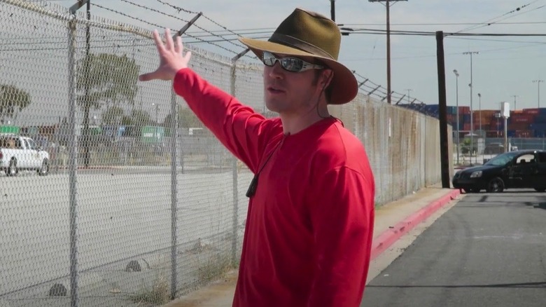 A stunt coordinator leads a safety meeting on a film set