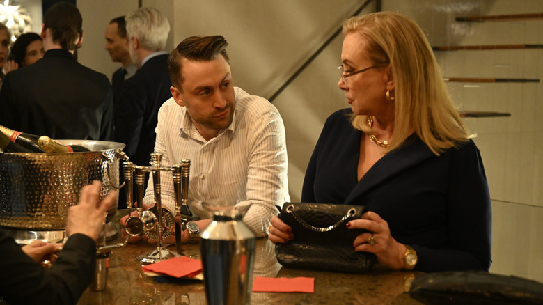 Roman and Gerri talking at the bar