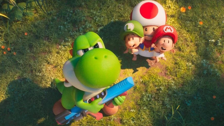 Yoshi looking serious defending Toad, baby Mario, and baby Luigi in The Super Mario Galaxy Movie