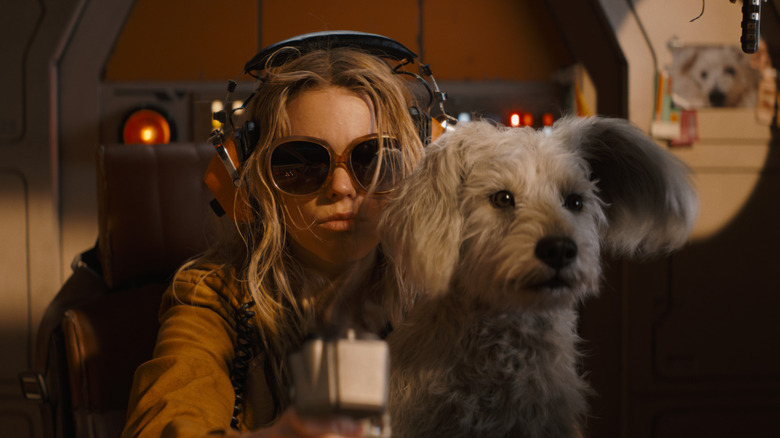 Kara wearing big sunglasses and holding Krypto while flying her ship in Supergirl (2026)
