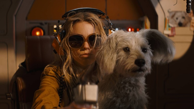 Kara wearing headphones with Krypto in her lap in Supergirl