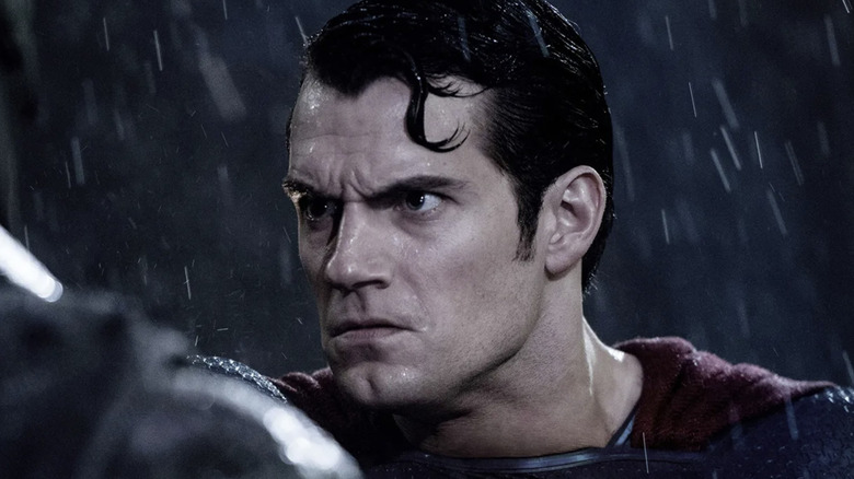 An angry Superman confronts Batman in the rain