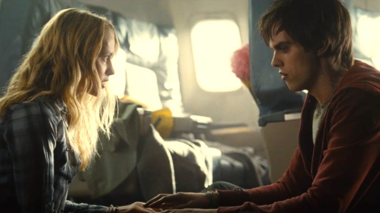 Julie and R sitting across from each other, touching hands in Warm Bodies (2013)
