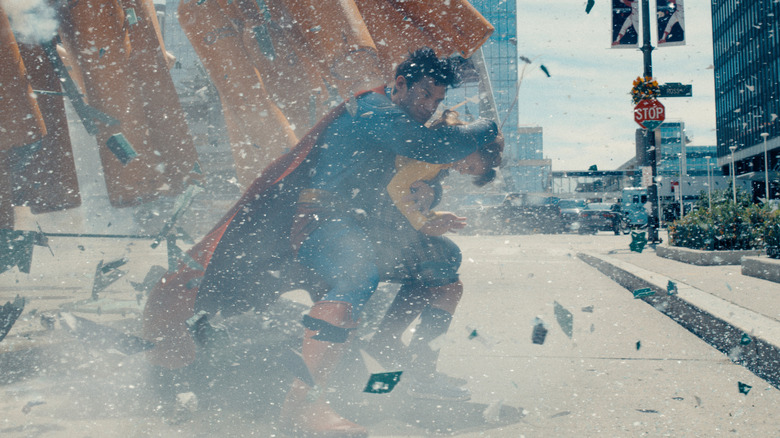 Superman protects a little girl from debris in "Superman" (2025)