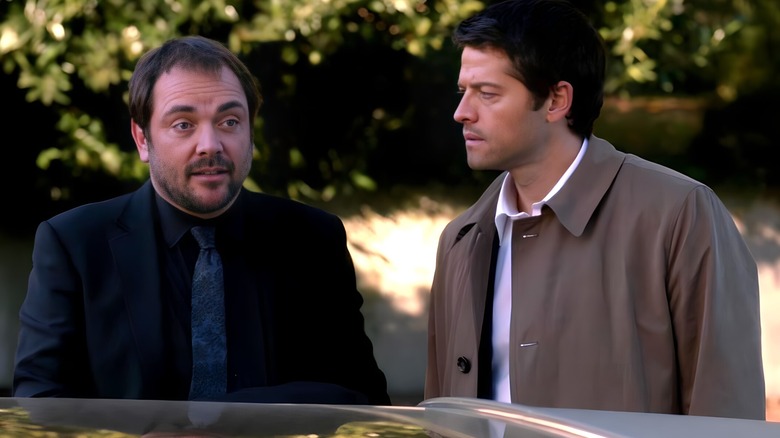 Crowley stands next to Castiel