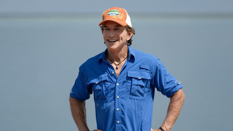 Jeff Probst smiling wearing a hat at a challenge in Survivor 49