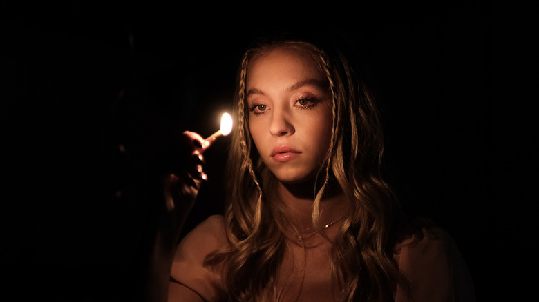 Cassie holding a lit match on Euphoria