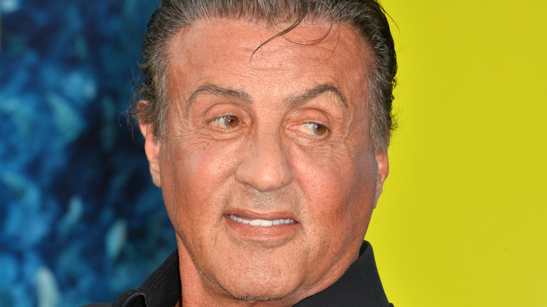 Sylvester Stallone smiling looks to side