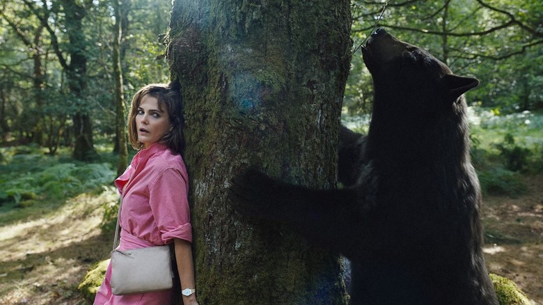 Cocaine Bear Keri Russell hiding from a bear