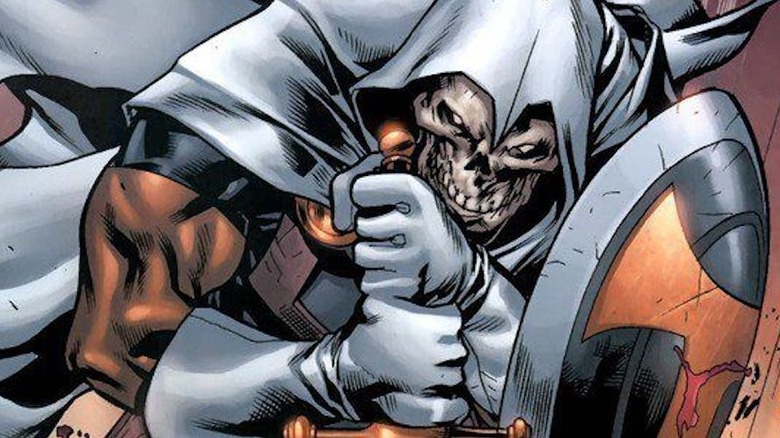 Taskmaster leans over clutching his sword.
