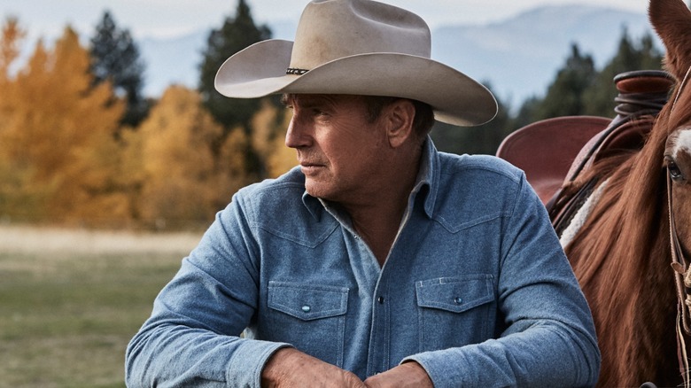 Kevin Costner standing a horse Yellowstone