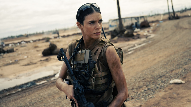 Cruz wearing sunglasses and holding a machine gun in Special Ops: Lioness