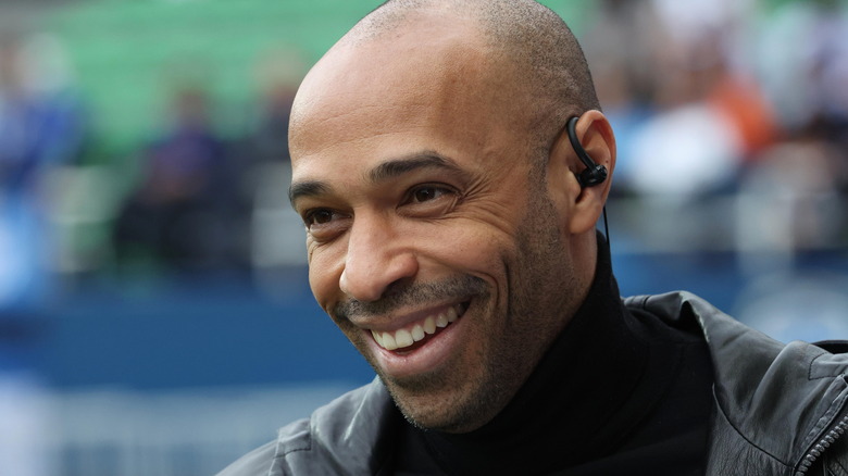 Thierry Henry laughing wearing earpiece