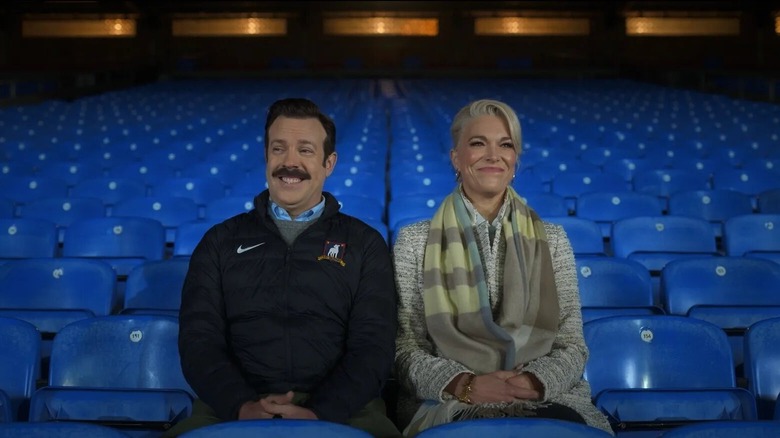 Ted and Rebecca sit in the stands