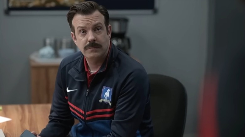 Ted Lasso sitting on a chair