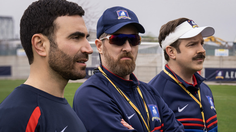 Roy, Beard, and Ted stand on a field together