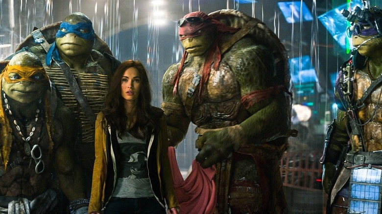 The Ninja Turtles hovering over April in "Teenage Mutant Ninja Turtles" (2014)