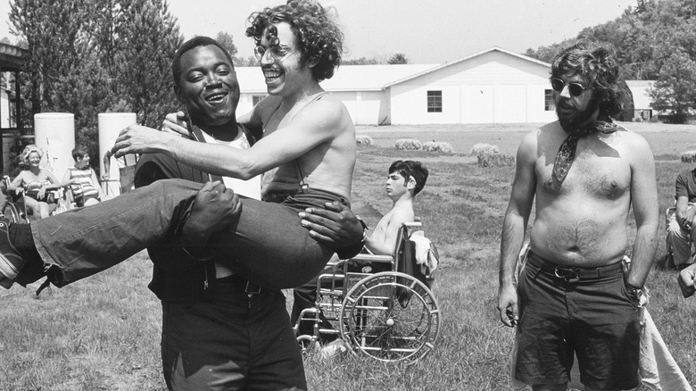 A black-and-white image, featuring three men in an open field, from Crip Camp: A Disability Revolution (2020)