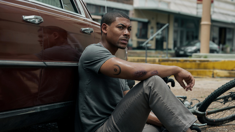 Aaron Pierre as Terry Richmond, leaning against a car in Rebel Ridge (2024)