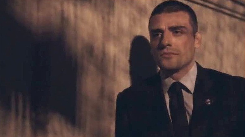 Oscar Isaac leaning on a wall