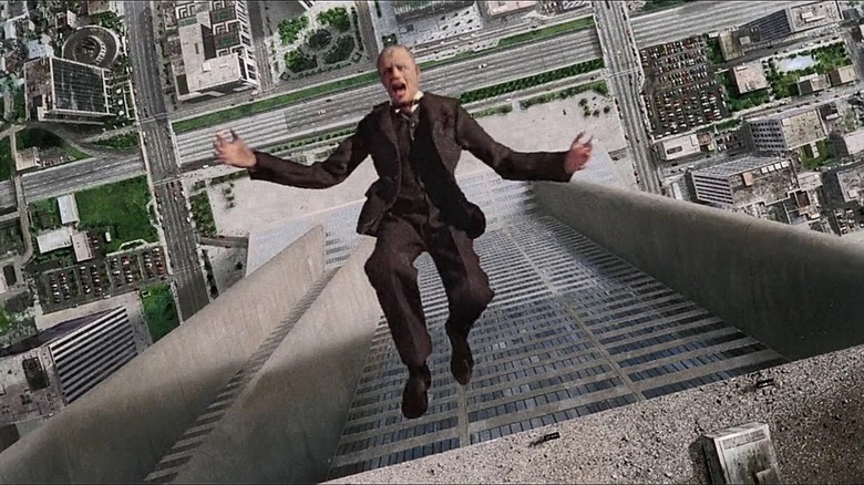 Dick Jones falls out the window