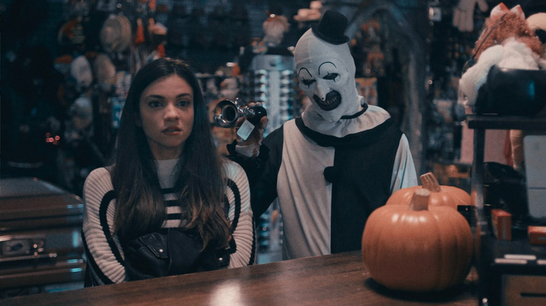 Art the Clown bothering Sienna with a horn at a costume shop in Terrifier 2