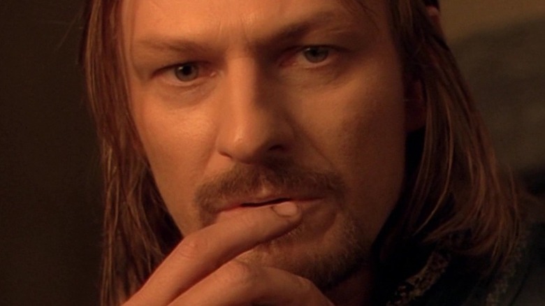 Boromir holding his hand to his face