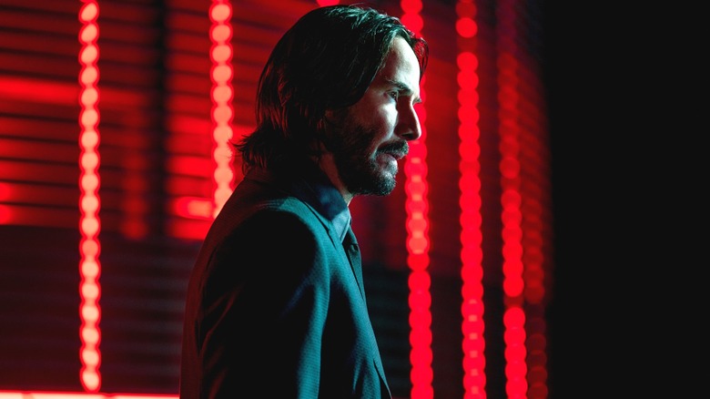 John Wick in front of red neon lights