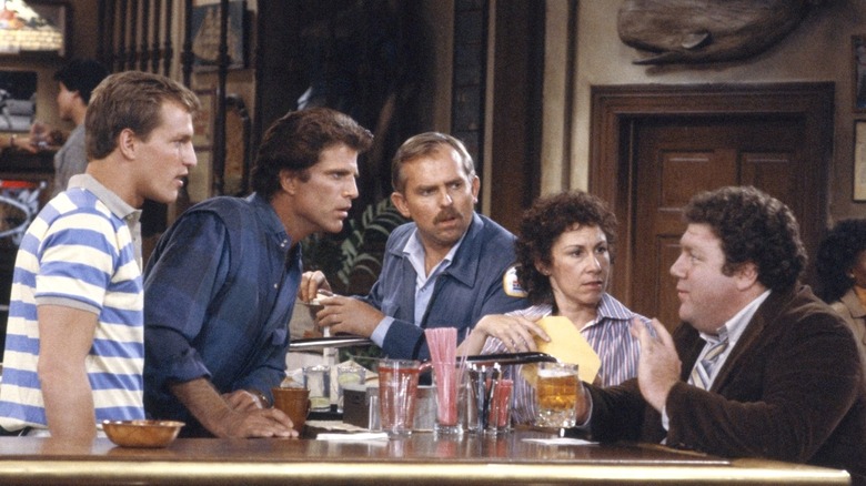Woody, Sam, Cliff, and Carla listening to Norm at the bar in "Cheers"