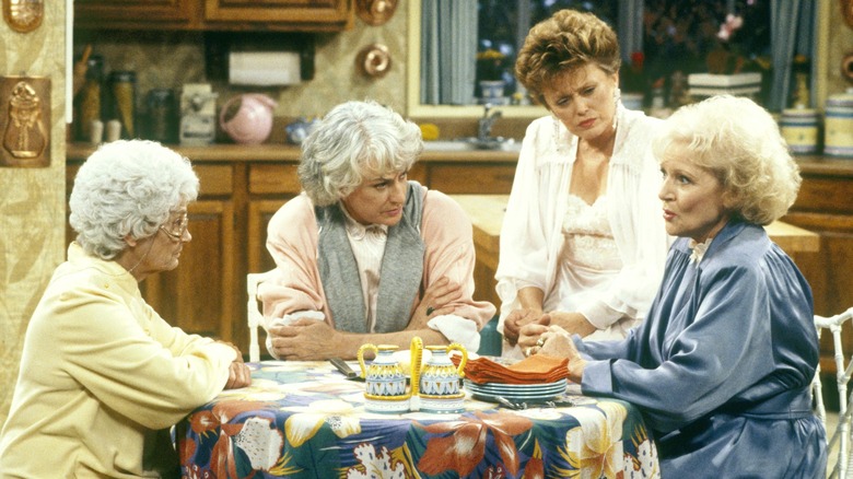 Dorothy, Rose, Blanche, and Sophia sitting around the table in "The Golden Girls"