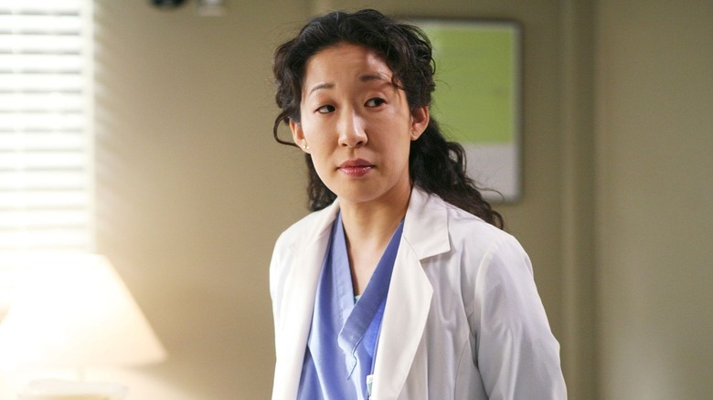 Cristina looking to the side in her white coat on Grey's Anatomy