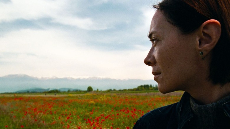 Nina watching over a field in "April" (2025)