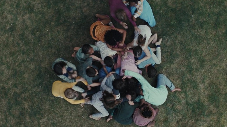 A mob of weaponized kids hold down Gladys in "Weapons" (2025)