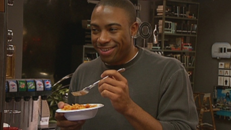 A cast member of The Real World: Cancun eating and smiling